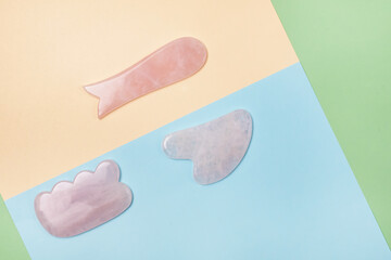 Facial and Body Stone Massage Instruments or Scrapers Gua Sha Lifting Skin Massage Color Block Background Minimal Top View