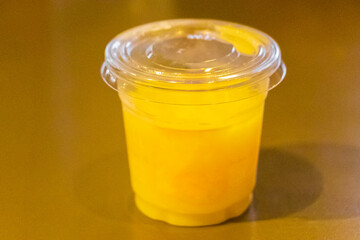 Plastic container with yellow liquid juice without logo for labeling.