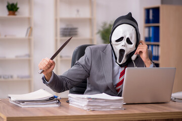Devil businessman employee sitting at workplace