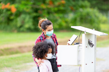 A young woman is checking the system of the watering control panel in the agricultural garden.