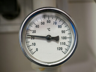 A temperature gauge showing the water temperature in the pipeline system in a private house. - obrazy, fototapety, plakaty
