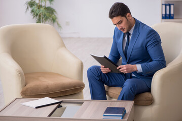 Young male employee waiting for business meeting