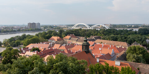 Obraz premium Renovated roofs of the old town below the Petrovaradin fortress and the Zezelj Bridge on the Danube River in Novi Sad, Serbia