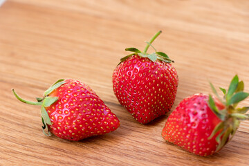 Strawberry. Fresh raw three berries on wooden background.
