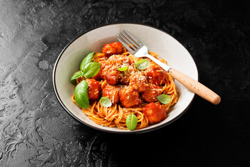 Spaghetti pasta portion with meatballs and tomato sauce.