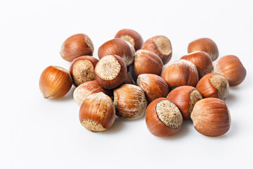 Stack of ripe hazelnuts on a white background. Filbert nuts. Wild hazelnut. Natural organic product. Copy space.