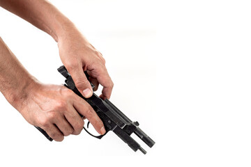 Hand holding a gun with a loaded magazine isolated on white background.
