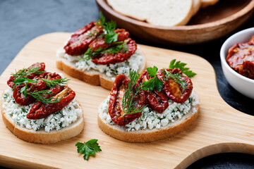 Bread slices with ricotta cheese and, sun dried tomatoes in olive oil.