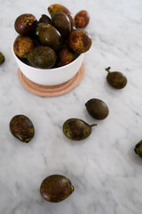 Matoa fruits from Papua Indonesia in the bowl on the marble table. Unique and rare fruit.