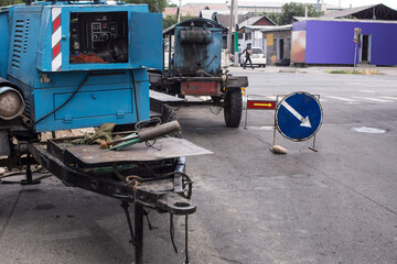 Diesel generators that supply electricity for welding on the street. The background is blurred for a depth effect.