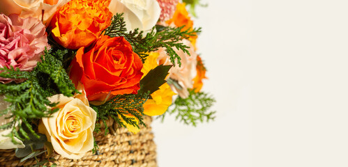 Beautiful bouquet of bright flowers close-up in basket with copy space. 
