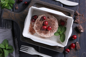 Healthy food. Breakfast for delivery. Cottage cheese, curd with fresh berries,lingonberry, chocolate and mint in a lunch box on a wooden table. Rustic. Background image, copy space