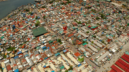 Poor area in the slums of Manila with density houses and streets from above.