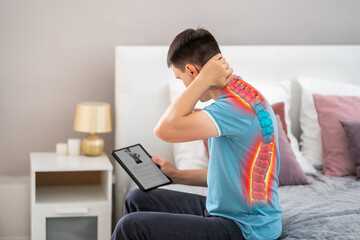 Lumbar and cervical spine hernia, man with back pain at home searches the Internet for symptoms of the disease, online medicine concept