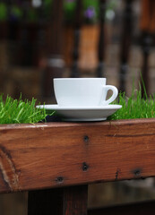 White cup with coffee on wooden table