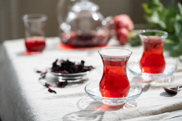 Hot red karkade tea in a glasses on rustic background