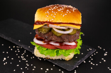 Big burger on a black background.
Close-up.