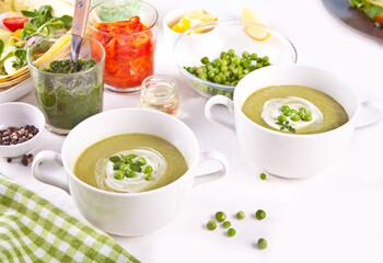 Delicious vegetable soup with potato, broccoli, green pea and spinach on the dinner table