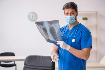 Young male doctor radiologist working in the clinic during pande