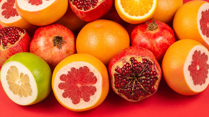 Naklejka na ściany i meble Grapefruit, orange, pomegranate, citrus sweetie on red background.