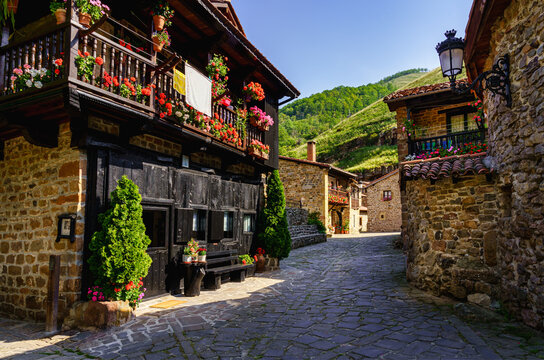 Picturesque stone houses with black wooden facade and narrow stone alley. Barcena Mayor Santander.