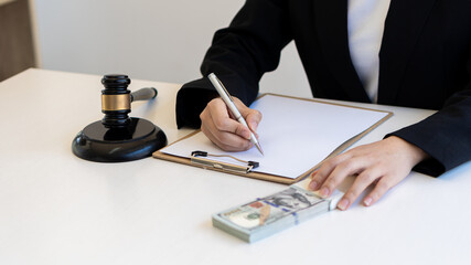 Lawyers work with papers on a table with dollars and a judge's hammer.