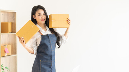 Beautiful Asian girl, SME businessman, online shopping working on laptop computer with parcel box - online SME business and delivery concept and working at home.