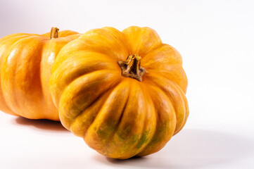 Two whole fresh orange big pumpkin on white background, closeup. Organic agricultural product,...
