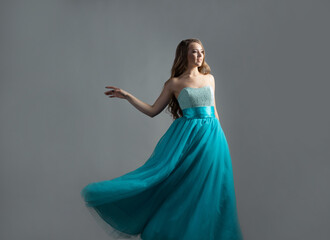 Fototapeta premium wonderful dancing princess in a lush blue dress, a young beautiful blonde