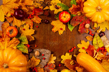 Autumn art composition - varied dried leaves, pumpkins, fruits, rowan berries on wooden background. Autumn, fall, halloween, thanksgiving day concept. Flat lay, top view, copy space. 