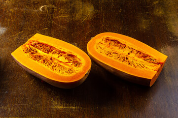 Cutted fresh orange big pumpkin on wooden background, close up. Organic agricultural product,...