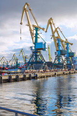 Fototapeta premium Industrial cranes, mooring wall, commercial sea port.
