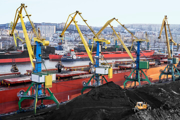Coal is loaded into the holds of a dry cargo ship in the seaport 24 hours a day.