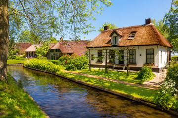 Fototapeta na wymiar The famous village of Giethoorn in the Netherlands with traditional dutch houses, gardens and water canals and wooden bridges is know as 