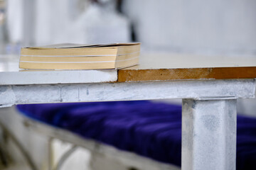 A book on the white color table and blue color carpet with blurred background.
