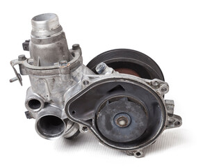 Metal automobile pump for cooling the engine of a water pump on a white background. The concept of used spare parts for the car engine from junkyard