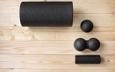 Foam roll, massage roll, balls on wooden background. MFR.