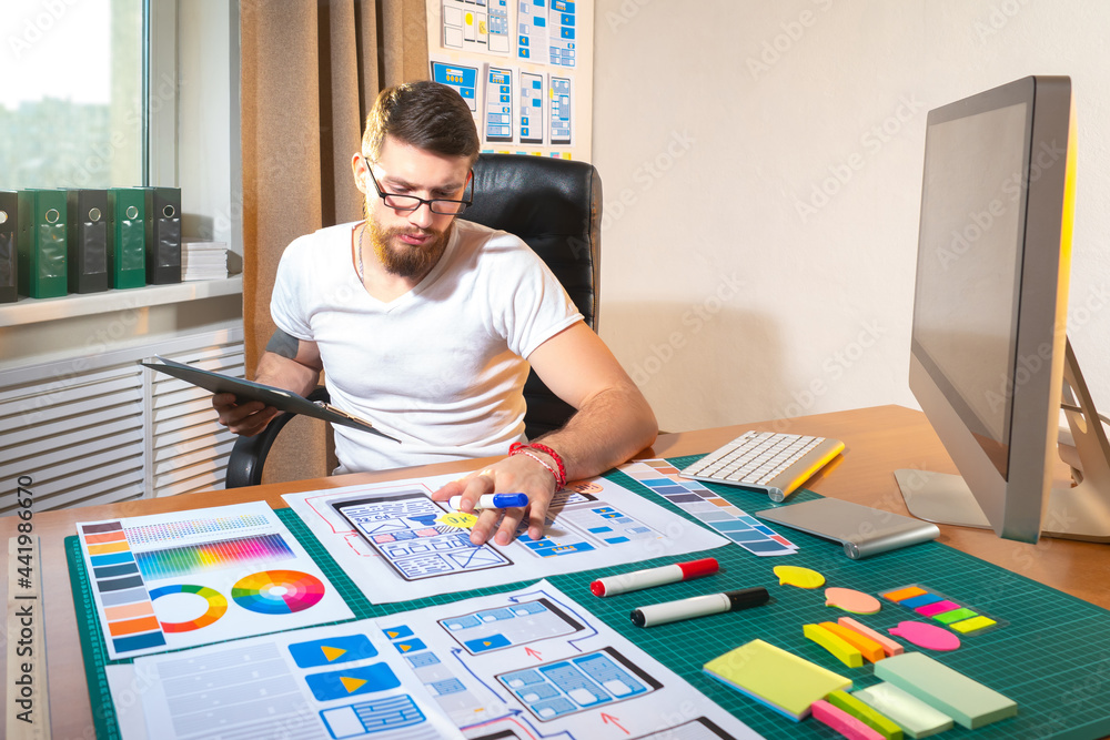 Poster ux designer at work. he draws app layouts on paper. ux designer career. application development proc