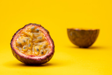 Slice of Maracuja or Brazilian tropical passion fruit showing the pulp flesh with out of focus the...