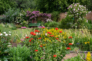 Fototapeta na wymiar Colourful herbaceous border photographed in late June at the historic walled garden tended by community volunteers in Eastcote, north west London UK.