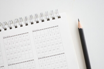 Sharp wooden pencil lying near paper calendar for 2021 closeup