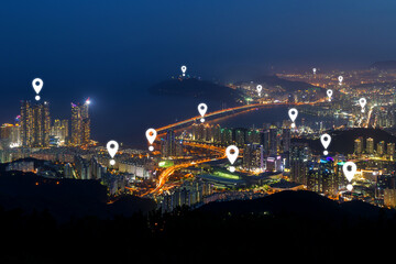Map pin icons on Busan's skyline at dusk. Scenic cityscape of Busan's urban skyline in South Korea from above at night.
