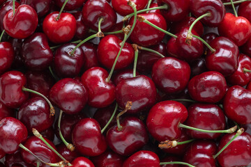 cherry close-up top view, a lot of red cherry berries are scattered on the table, sweet cherry background