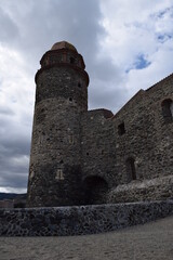 Obraz premium Castillo de época medieval de piedra con torre alta en un día nublado con cielo azul de fondo