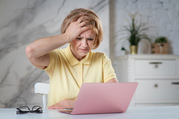 Portrait of angry stressed elderly senior woman, tired lady having problems with using her broken...
