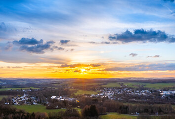 Naklejka na ściany i meble Sunset, Aerial view over forests and meadows of Westerwald, Altenkirchen, Germany