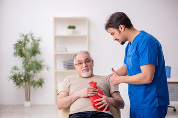 Obraz premium Old male patient visting young male doctor gastroenterologist