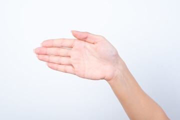 Woman's hand with pink manicure over isolated white background pointing aside with the palm of the hand, indicating to the left. 