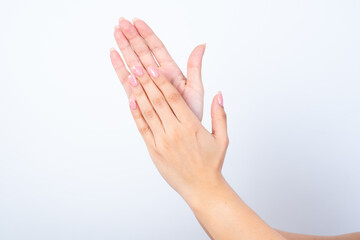 Woman's hands with pink manicure over isolated white background  clapping. 