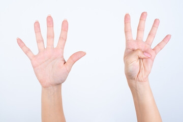 Woman's hands with pink manicure over isolated white background pointing with fingers number nine.